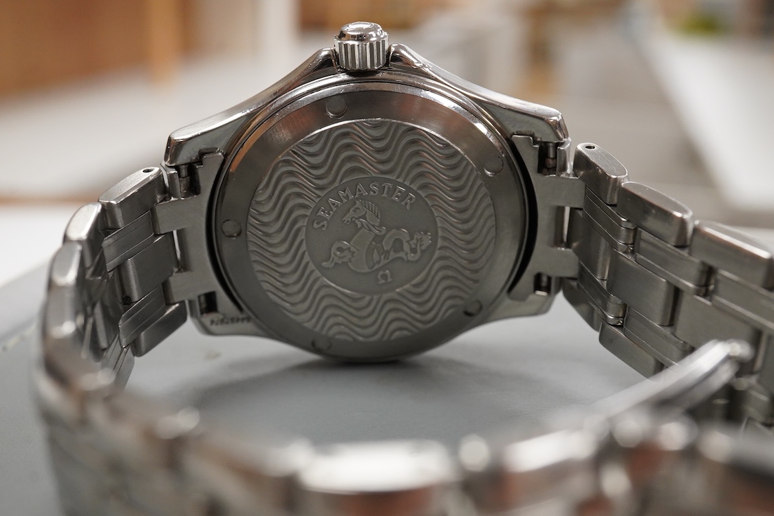 A gentleman's 1990's stainless steel Omega Seamaster quartz wrist watch, with blue dial dot markers and date aperture, case diameter 36mm, on a stainless steel Omega bracelet, with box and papers.